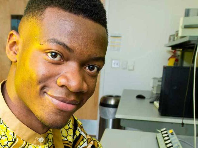 Man sitting at a desk smiling for a picture