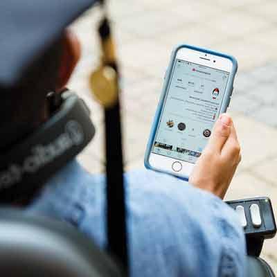 ksu student in wheel chair looking at app on phone